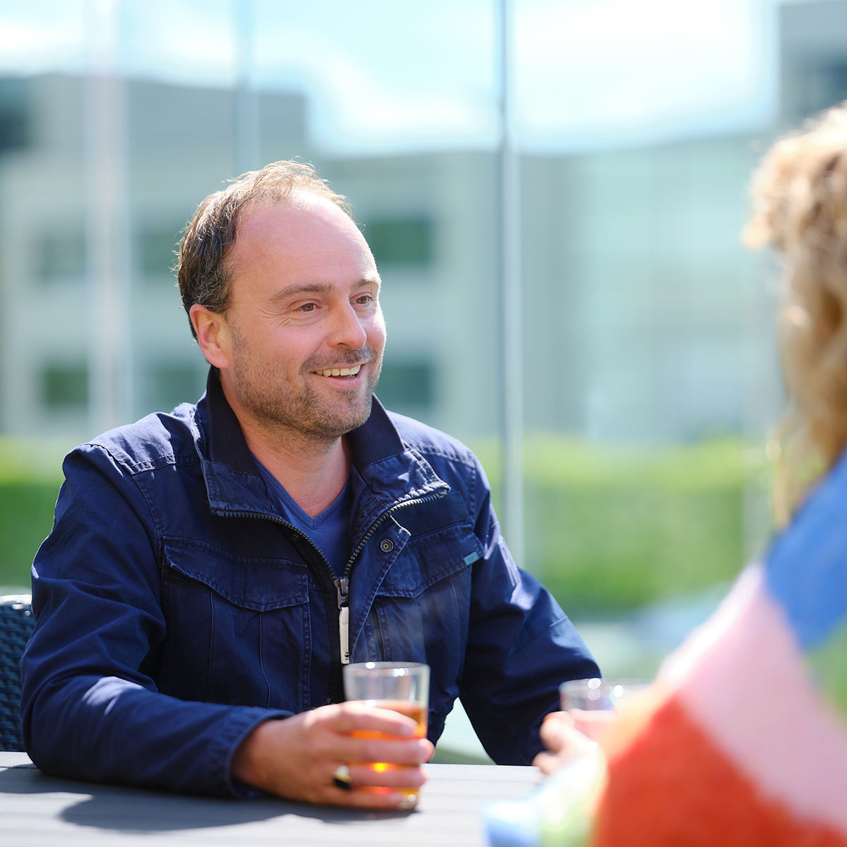 Foto van deelnemers op het balkon van het onderzoekscentrum met een glas drinken